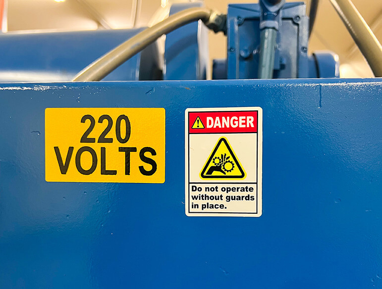 Do not operate without guards danger sign on blue machine parts
