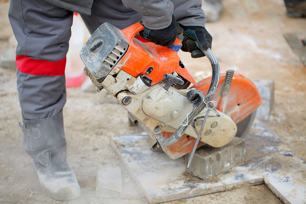 Builder working circular saw construction road