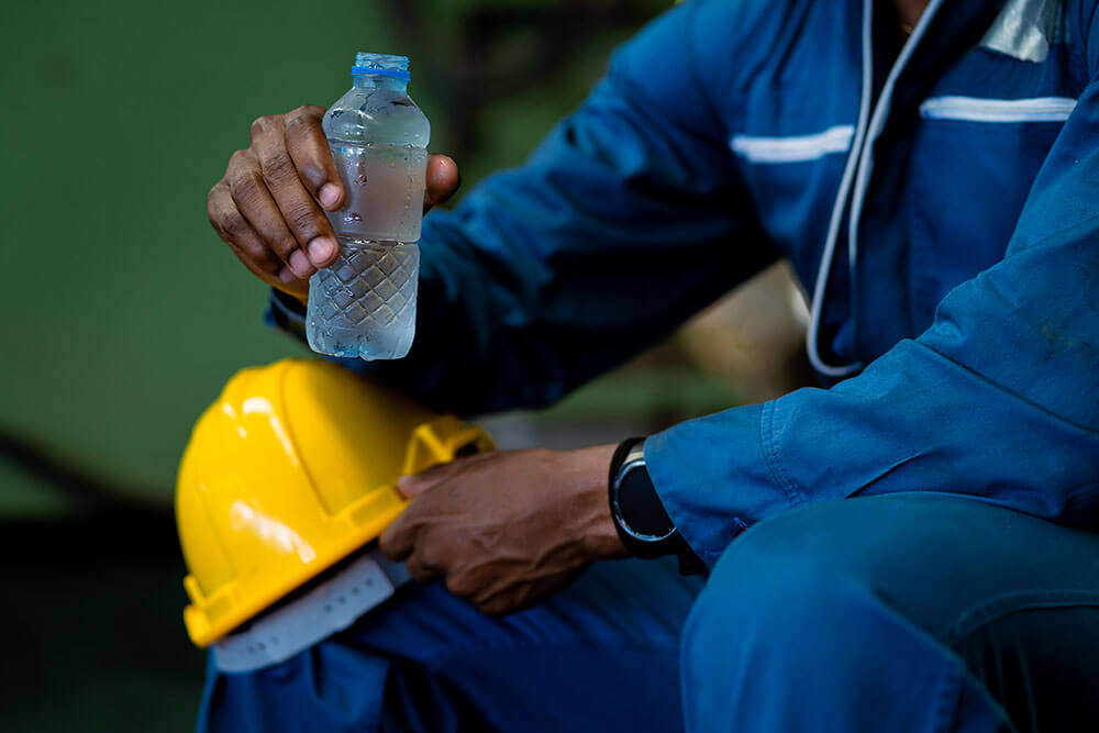 Worker drinking water from bottle during work break
